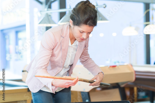 attractive brunette woman checking billiards stick photo