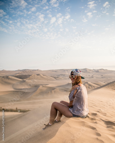 woman sitting on a top of a dune