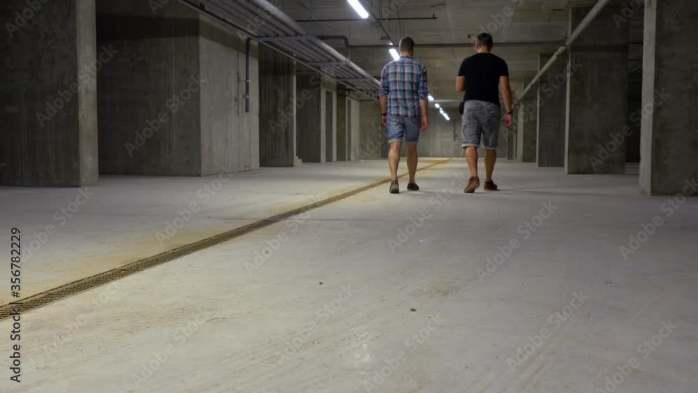 Low angle view of two men walking away Low angle view of two men walking away