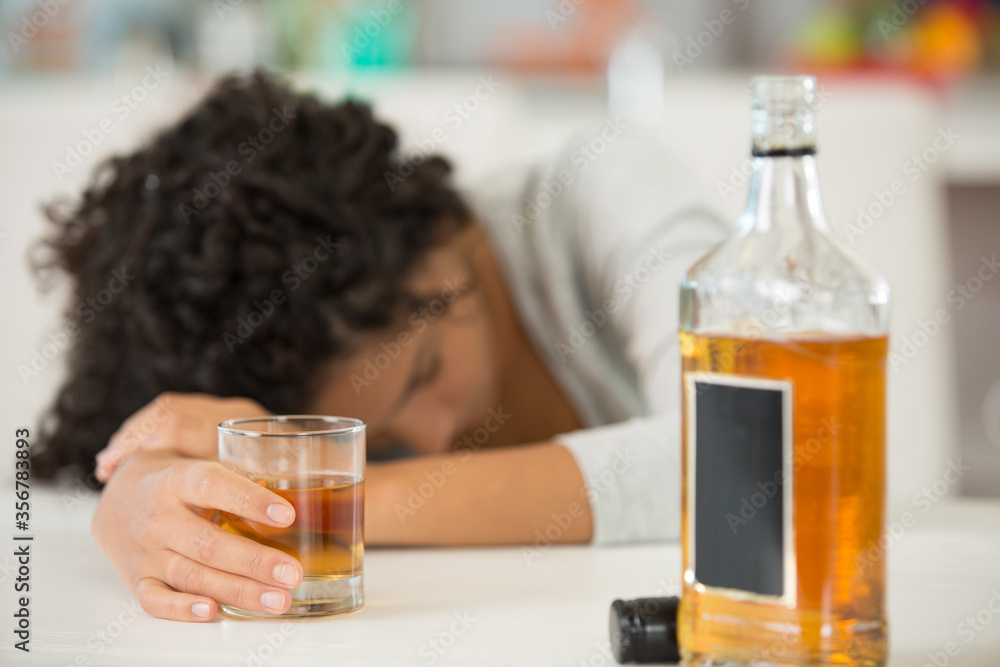 unconscious drunk woman and glass of whiskey unconscious drunk woman and glass of whiskey