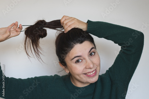 Bilde på lerret Woman tying her hair