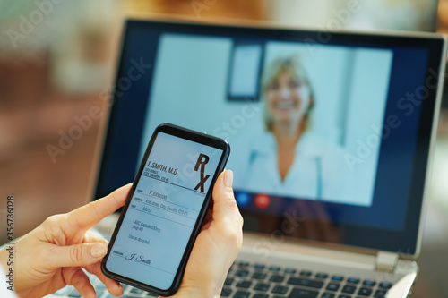 modern woman with electronic rx and doctor on video call photo