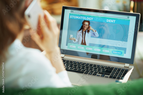 Φωτογραφία woman using mobile phone and looking at digital dental site