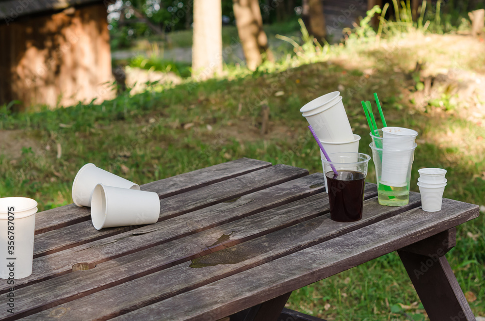 Empty dirty plastic and disposable cups, left on a wooden table, after have been used. Empty dirty plastic and disposable cups, left on a wooden table, after have been used.