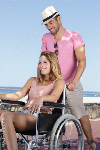 cheerful couple sititng in the wheelchairs outdoors © auremar