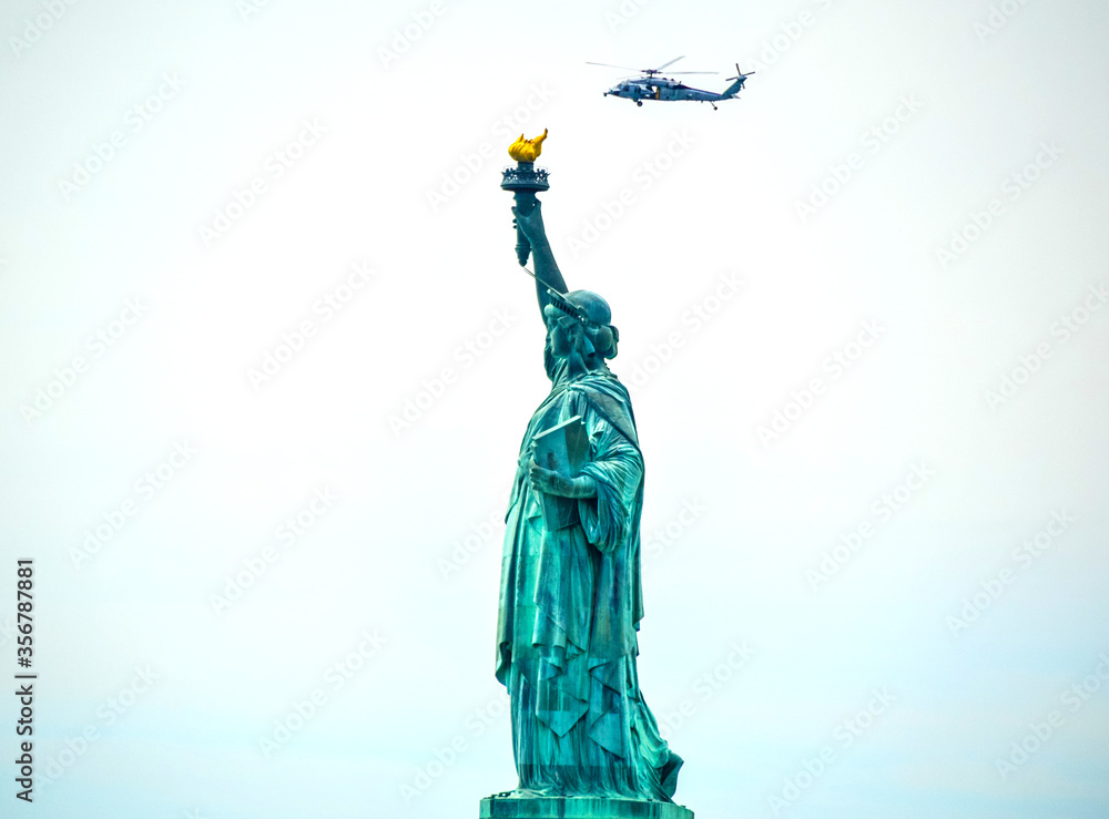 A navy helicopter is flying around Statue of Liberty in New York City, USA.