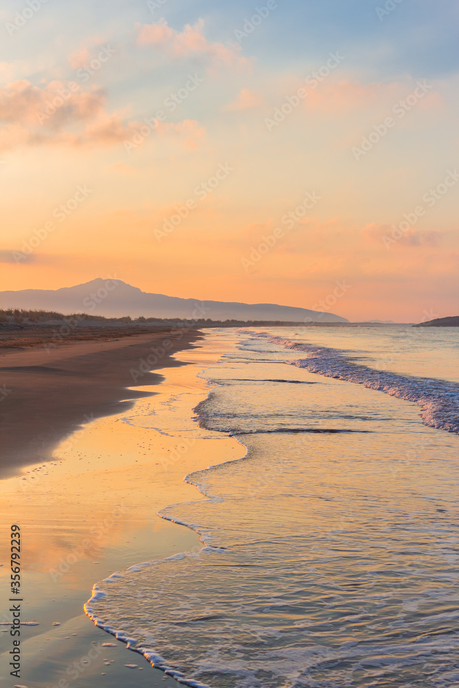 Naklejka premium Picturesque Mediterranean seascape in Turkey. Amazing sunrise on Patara beach, Mugla Province. Morning orange clouds reflected in calm water.