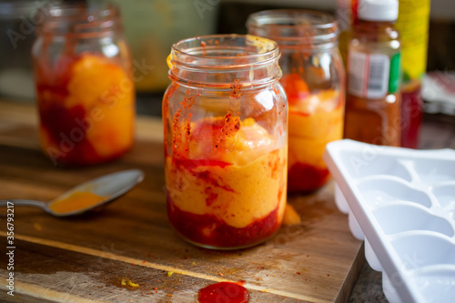 A view of several glass jars with a Mexican summer drink known as chamango, in a home kitchen setting. photo