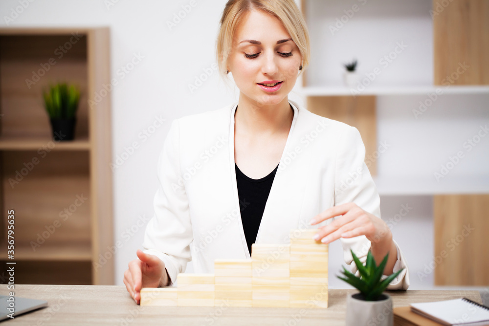 Business concept, woman builds a company development strategy from wooden cube Business concept, woman builds a company development strategy from wooden cube
