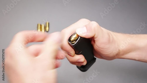 Man quickly loading ammunition into polymer pistol magazine