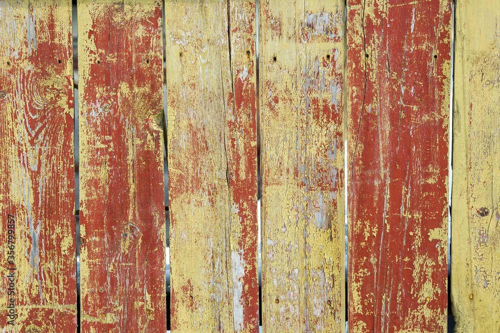 Picket fence with peeling paint. Wood texture. Old rough and cracked planks. Close-up. Perfect for background and design. Picket fence with peeling paint. Wood texture. Old rough and cracked planks. Close-up. Perfect for background and design.
