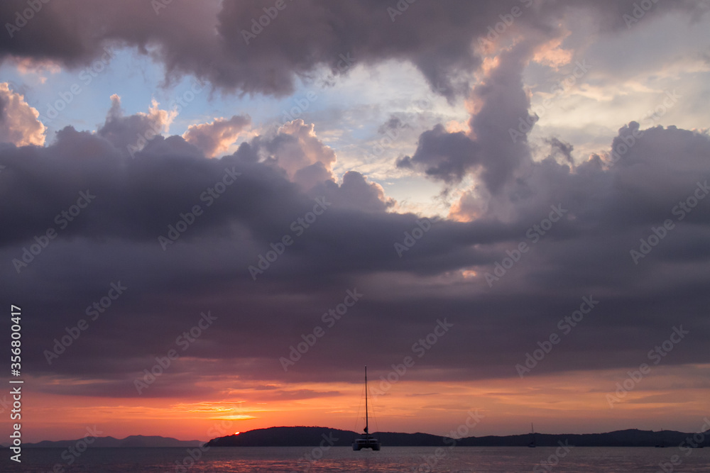 KATAMARAN WITHOUT SAIL ON A BACKGROUND OF CLOSING CLOUDS