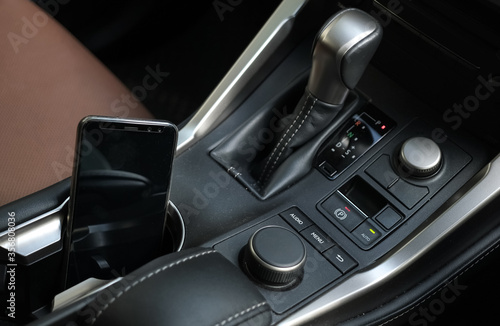 car interior with smartphone on cup holder 