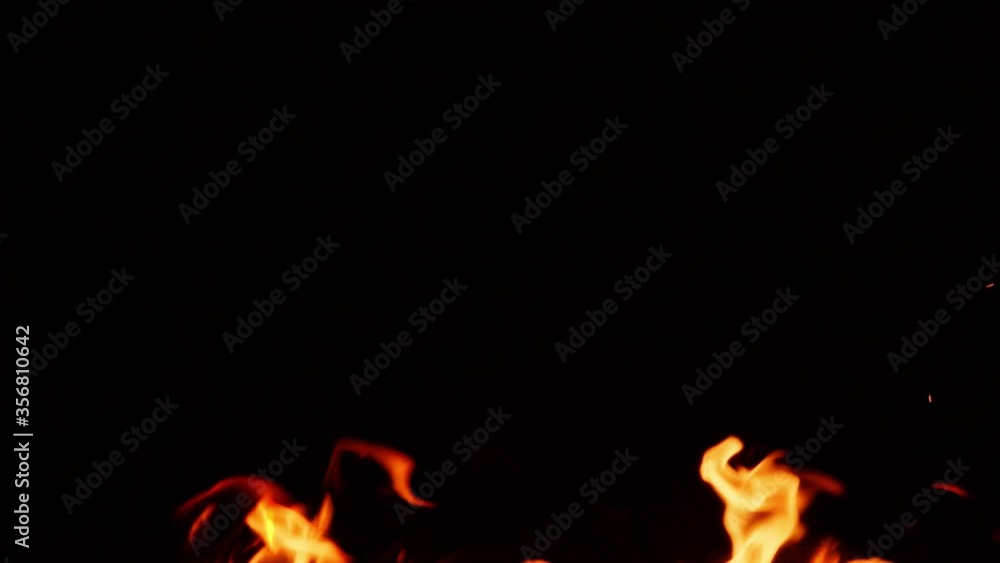 Flames from campfire burning at night, close-up of flames burning in slow motion on black background Flames from campfire burning at night, close-up of flames burning in slow motion on black background