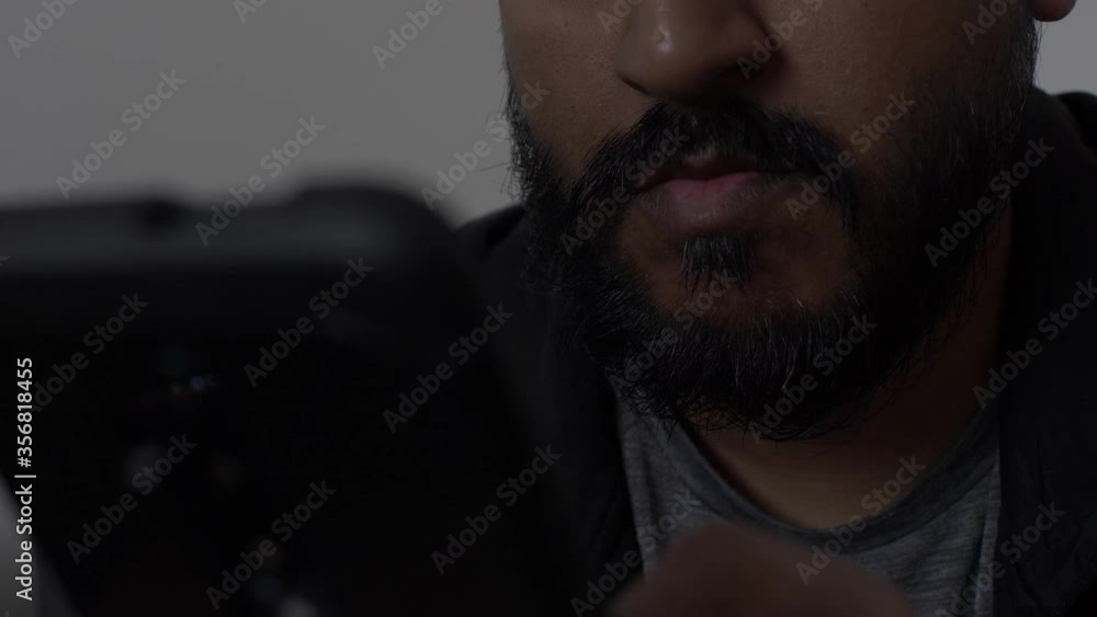 Low Angle View Of UK Asian Male Using Mobile Phone Indoors. Background Focus Low Angle View Of UK Asian Male Using Mobile Phone Indoors. Background Focus