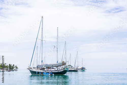 Beautiful seascape of blue sea with floating yacht and white cloud sky. luxury summer day lifestyle vacation tourism travel in Guna Yala, San Blas Islands, Panama, Central America - Horizontal wide