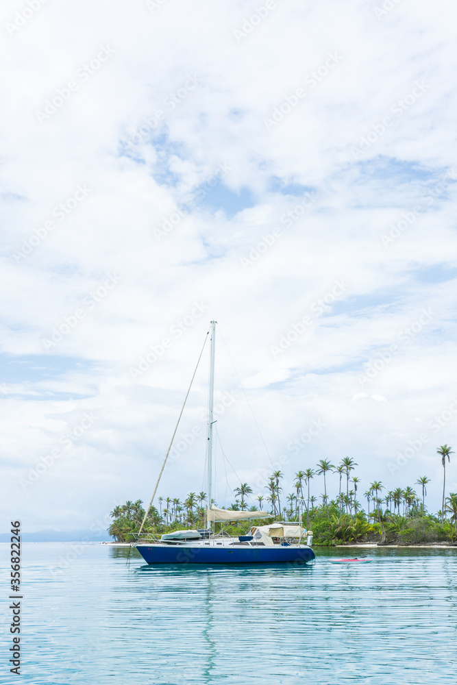 Beautiful seascape of blue sea with floating yacht and white cloud sky. luxury summer day lifestyle vacation tourism travel in Guna Yala, San Blas Islands, Panama, Central America - Vertical shot