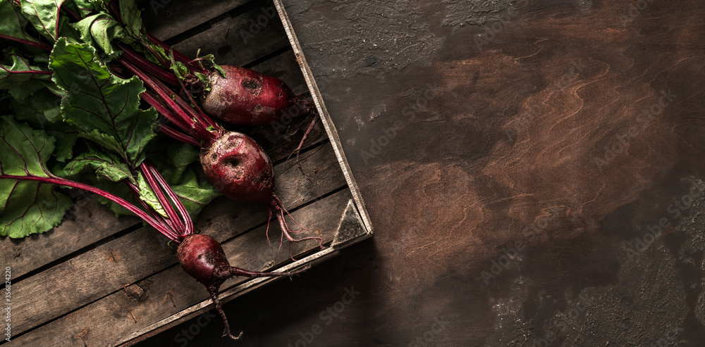 Beetroot in wooden box on dark background. Fresh vegetables, healthy organic food, harvest, agriculture, top view - obrazy, fototapety, plakaty 