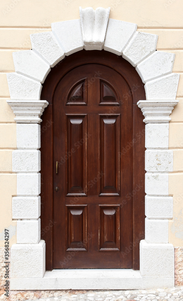 Brown door in facade of residential building surrounded by bricks Brown door in facade of residential building surrounded by bricks