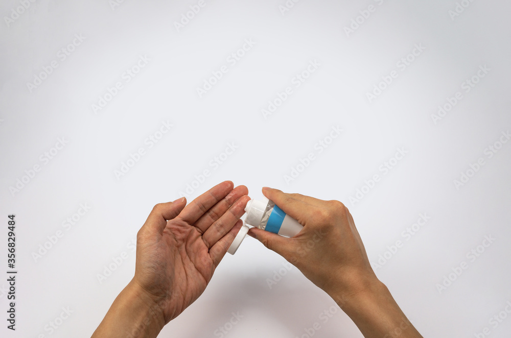 Using alcohol gel on hand for sanitizing  - close up on white empty background