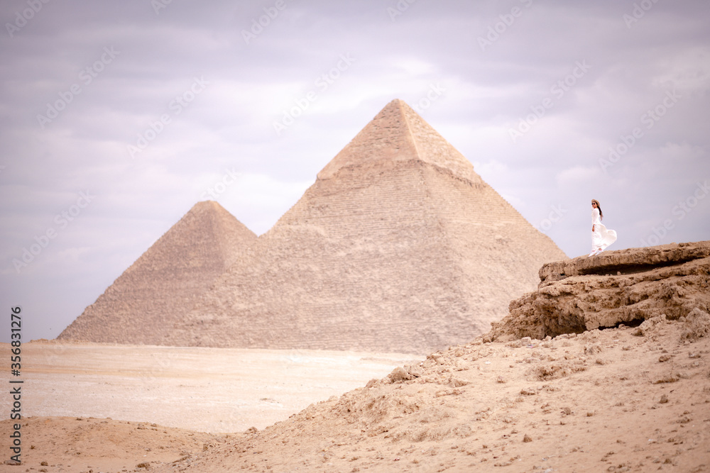 Asian woman stand and see the great pyramids of Giza, Cairo, Egypt from the small hills. Asian woman stand and see the great pyramids of Giza, Cairo, Egypt from the small hills.