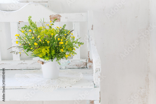 Fototapeta Naklejka Na Ścianę i Meble -  flowers in bucket on old white wooden bench indoor
