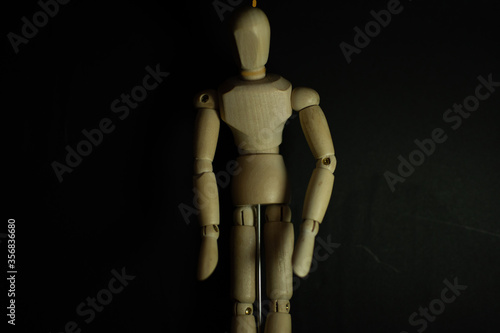 wooden mannequin hang man on black background