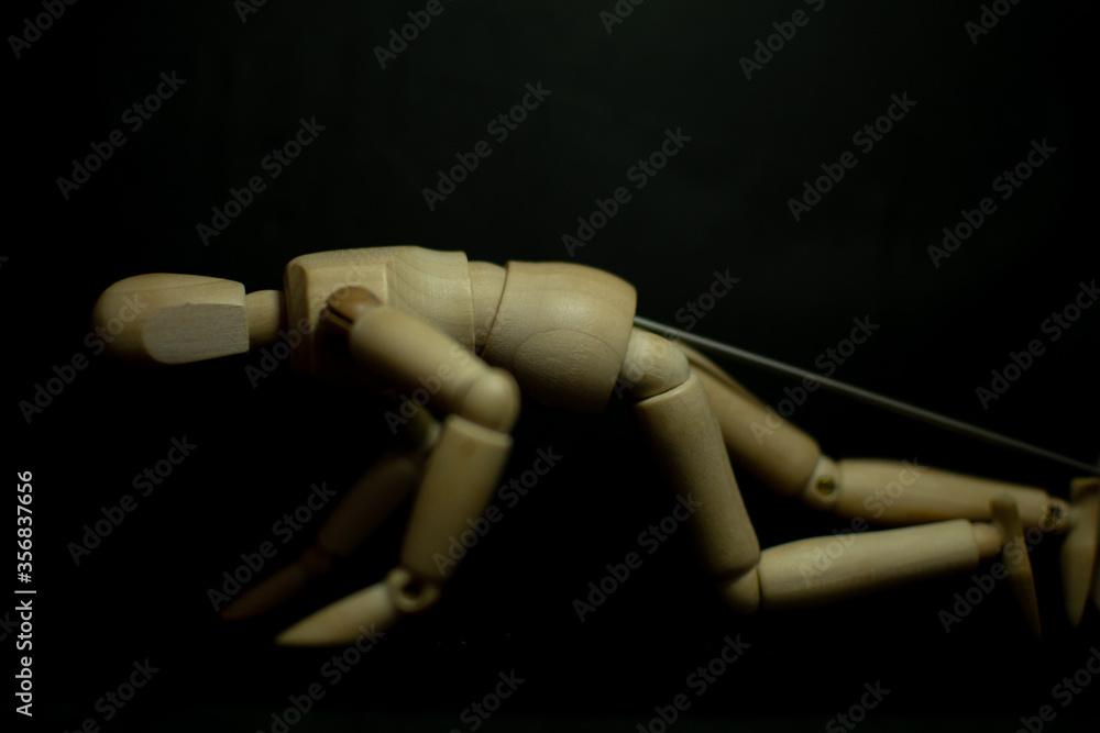 wooden mannequin clawing floor pose on black background wooden mannequin clawing floor pose on black background
