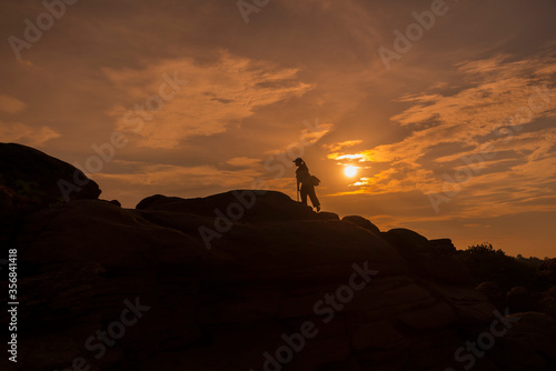 The silhouette of a woman walking up the hill