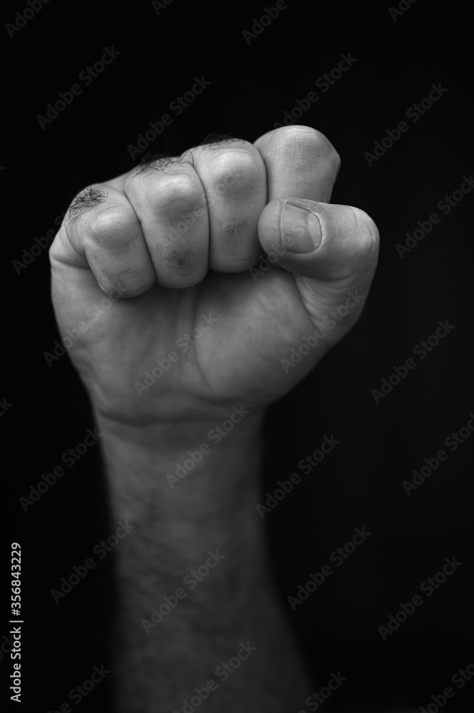 Male raised fist isolated on black background Male raised fist isolated on black background