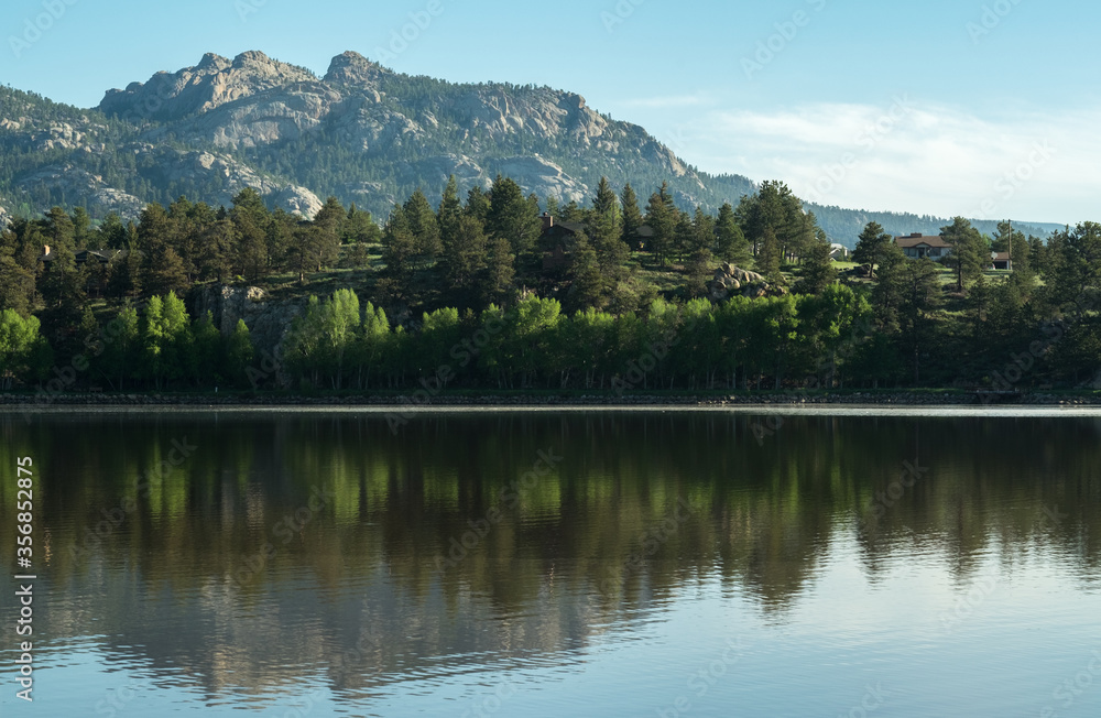 Reflective lake with trees and mountain