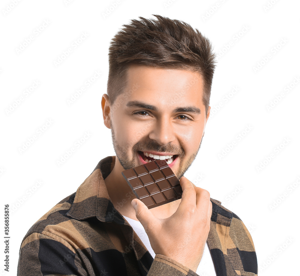 Handsome young man with tasty chocolate on white background Handsome young man with tasty chocolate on white background