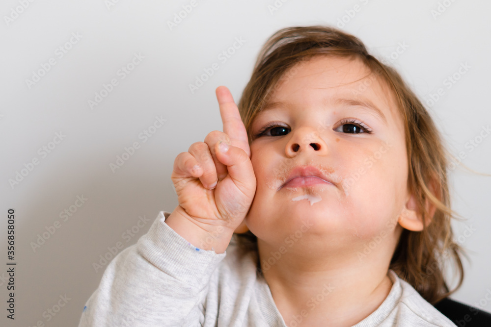 Toddler with one finger upwards. Girl child portrait close up. Lifestyle math learning in preschool Toddler with one finger upwards. Girl child portrait close up. Lifestyle math learning in preschool