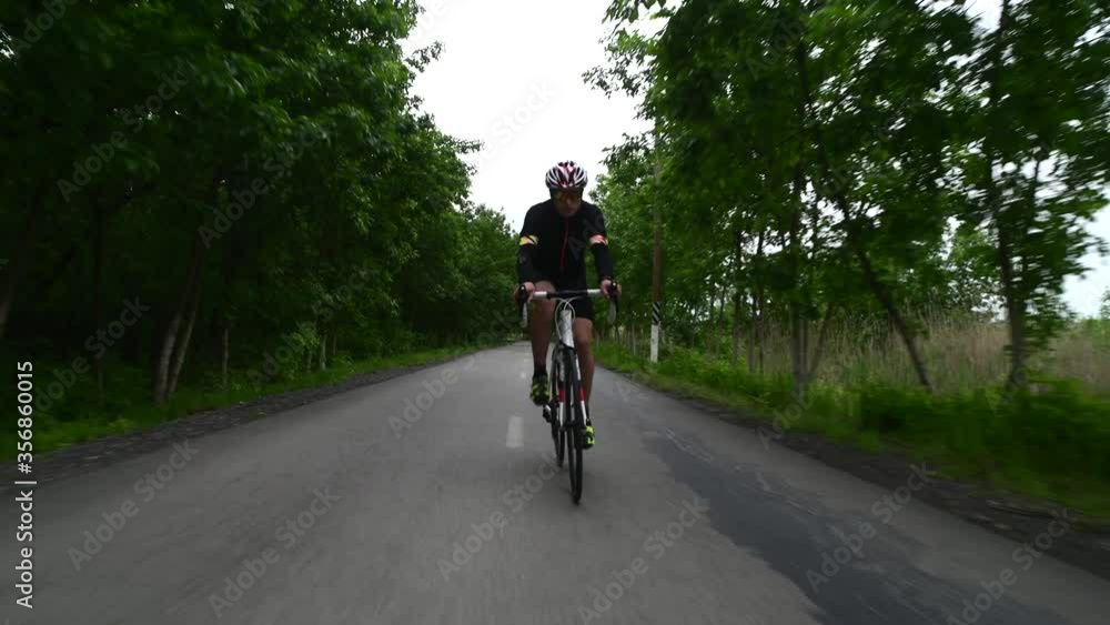 Pro bicyclist cycling road bike, sport concept, mountain road at sunset Pro bicyclist cycling road bike, sport concept, mountain road at sunset