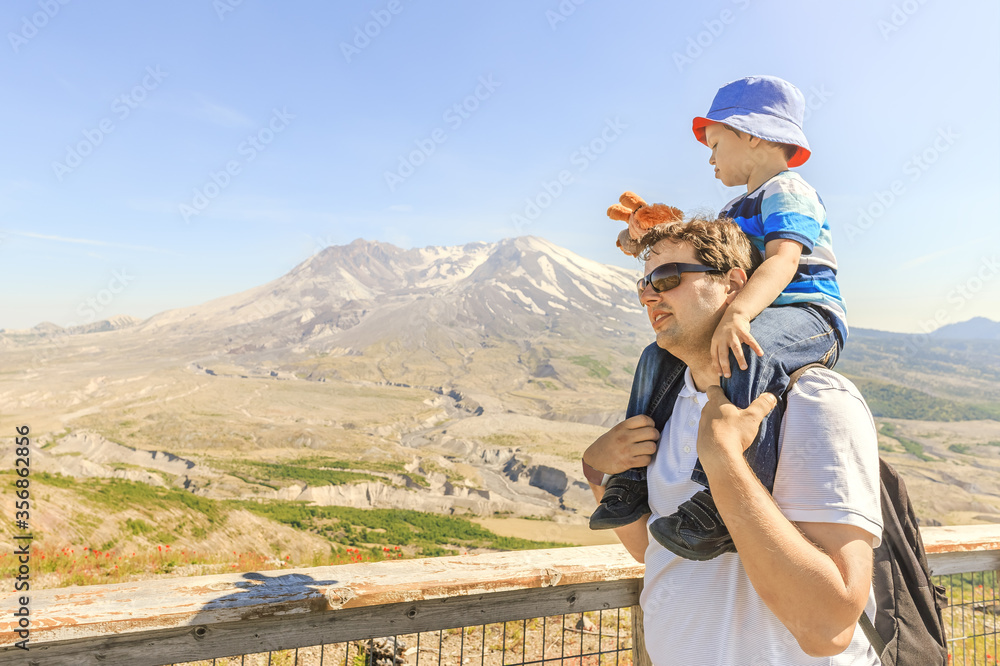 Naklejka premium Father and son with Mt. St. Helens in a background