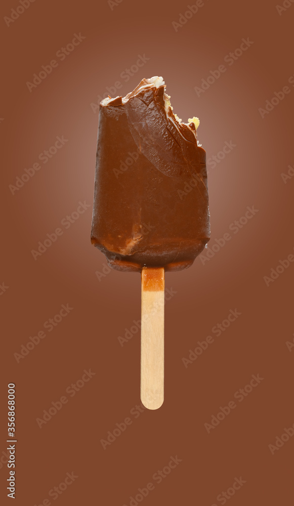 Obraz premium fresh chocolate outer popsicle with some bites on brown background