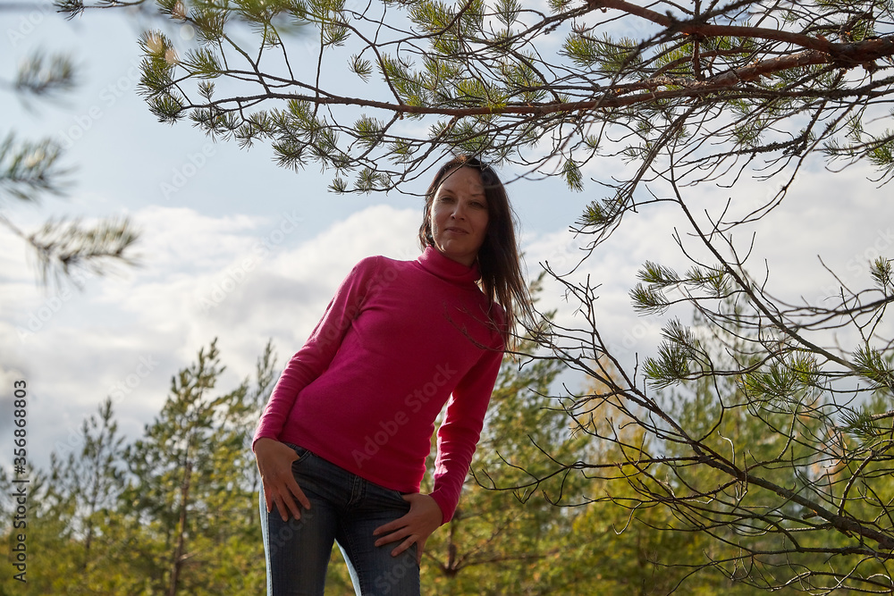 Beautiful young woman walking in the forest with sprice in autumn Beautiful young woman walking in the forest with sprice in autumn