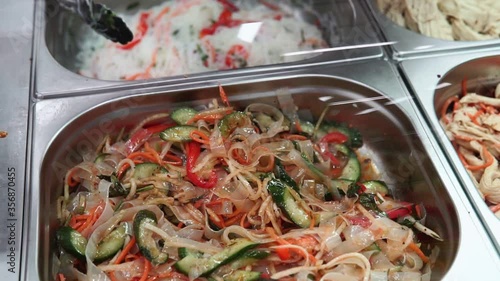 starch noodle salad with carrots and spices. sale of a ready-made dish on the market. Korean cuisine photo