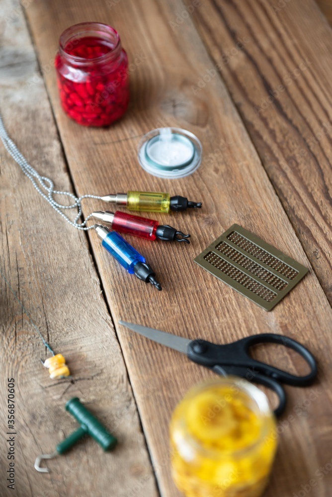 carp fishing tools and baits isolated on wooden table