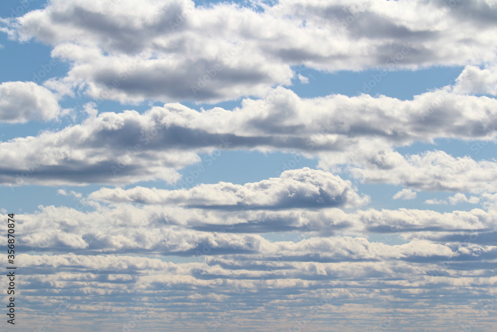 Fototapeta premium White fluffy clouds on a background of blue sky in summer. The concept of weather and climate