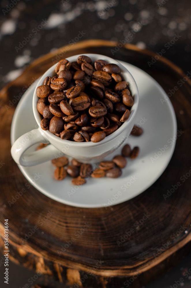 Fototapeta premium coffee beans in a small white cup. sprinkled coffee beans
