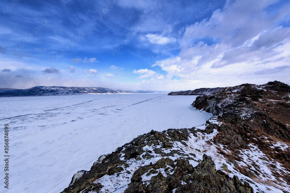 View of winter landscape in Siberia with frozen lake Baikal in the distance. Winter in Russia