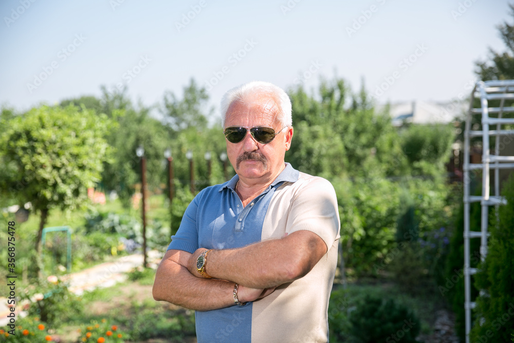 Senior grey-haired man in sunglasses in summer Senior grey-haired man in sunglasses in summer