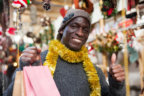 Smiling man with shopping bags on Christmas fair