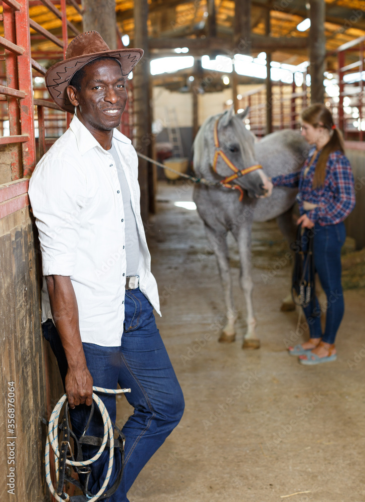 Man in working clothes posing at stable