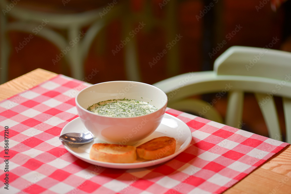 Okroshka. Summer light cold yogurt soup with cucumber, radish, eggs and dill in a bowl. Dinner in restaurant. Okroshka. Summer light cold yogurt soup with cucumber, radish, eggs and dill in a bowl. Dinner in restaurant.