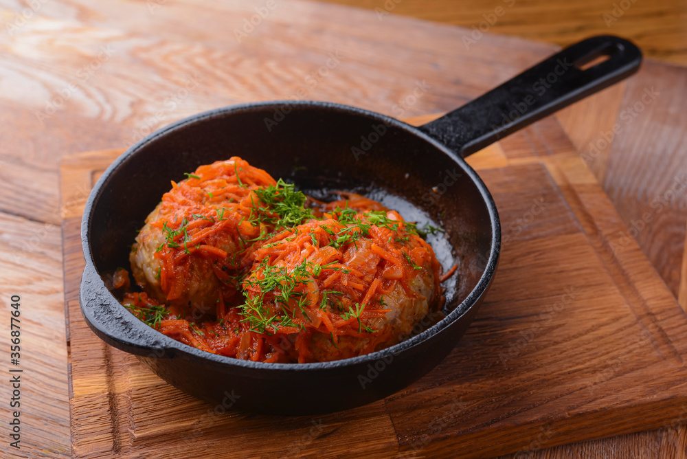 Stew with vegetables and meat - a simple stew in a pan. Served on a wooden board over rustic wooden background. Stew with vegetables and meat - a simple stew in a pan. Served on a wooden board over rustic wooden background.