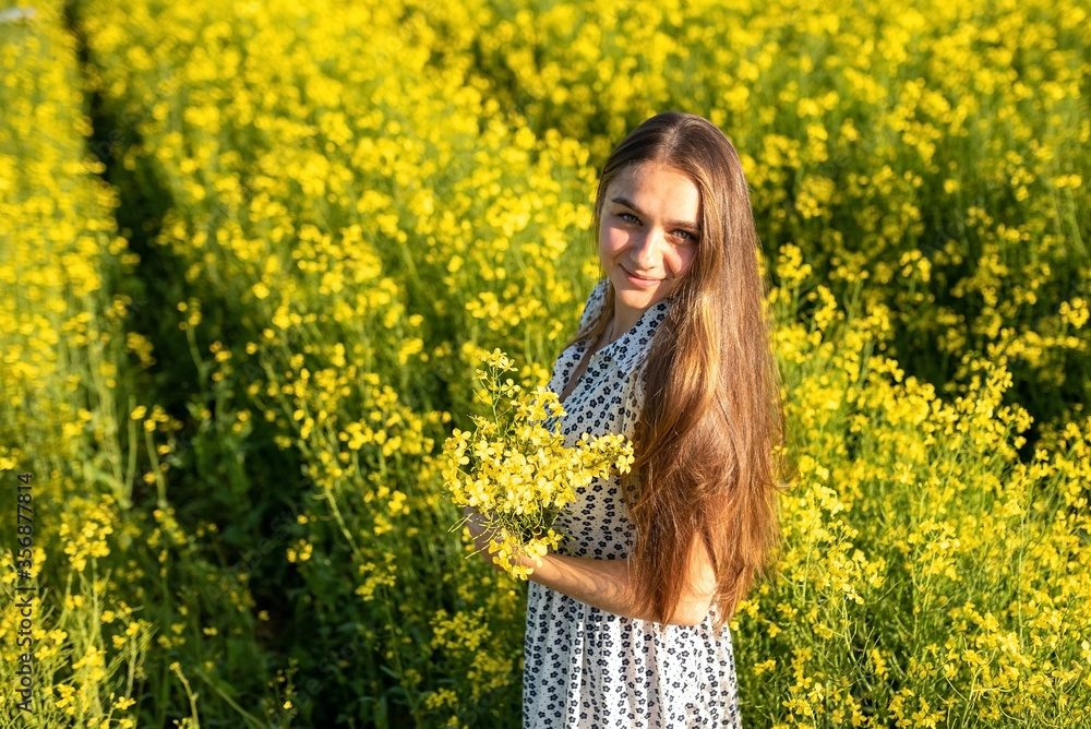 Girl in a rapeseed field in the sun. Girl in a rapeseed field in the sun.