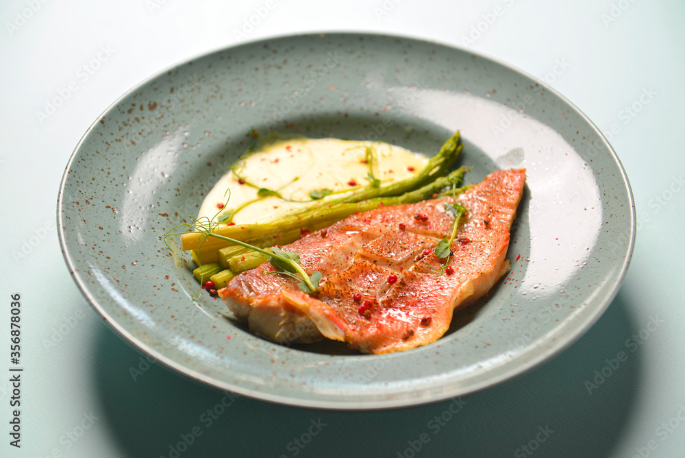 Grilled meat steak with sauce and spices served on a plate over bright pastel blue mint background. Grilled meat steak with sauce and spices served on a plate over bright pastel blue mint background.