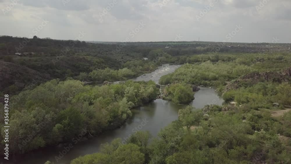 Aerial view to granite mountains, islands and rapids on Southern Bug river, surrounded by trees and grasses, Mihiia village. Ukraine. Famous place for rafting and kayaking Aerial view to granite mountains, islands and rapids on Southern Bug river, surrounded by trees and grasses, Mihiia village. Ukraine. Famous place for rafting and kayaking